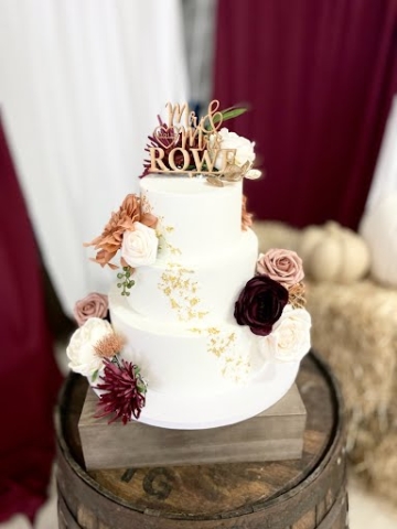 Tiered wedding cake with artificial flowers.