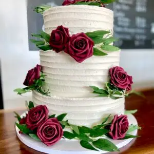 3-Tiered rustic line cake with artificial flowers and greenery
