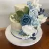 Blue and white wedding cake with artificial flowers