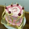 Lambeth heart 2-color with light pink and pink icing, cherries, and light yellow ribbon