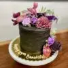 6" Rustic Spackle w/ black icing and purple artificial flowers