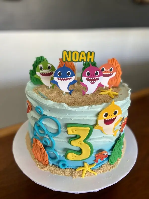 8" Icing texture Baby Shark theme with fondant details and edible images on side, and paper toppers