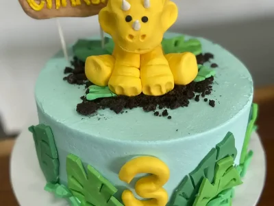 Dino themed cake with fondant decorations and topper